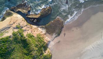 An aerial view of waves crashing against a shore.
