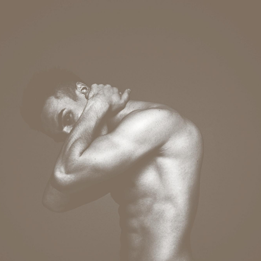 Zdjęcie mężczyzny bez koszulki od boku.